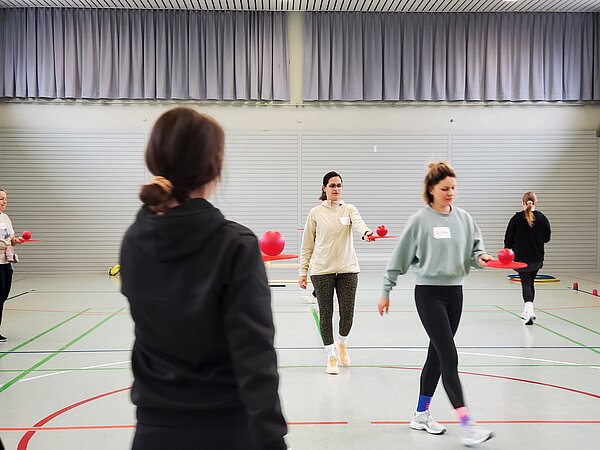 Gruppe beim Transport-Spiel mit Bällen